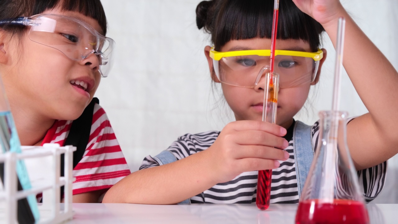 孩子们正在教室里学习和做科学实验。两个小妹妹在家玩科学实验。让孩子在家做简单有趣的科学实验。视频素材