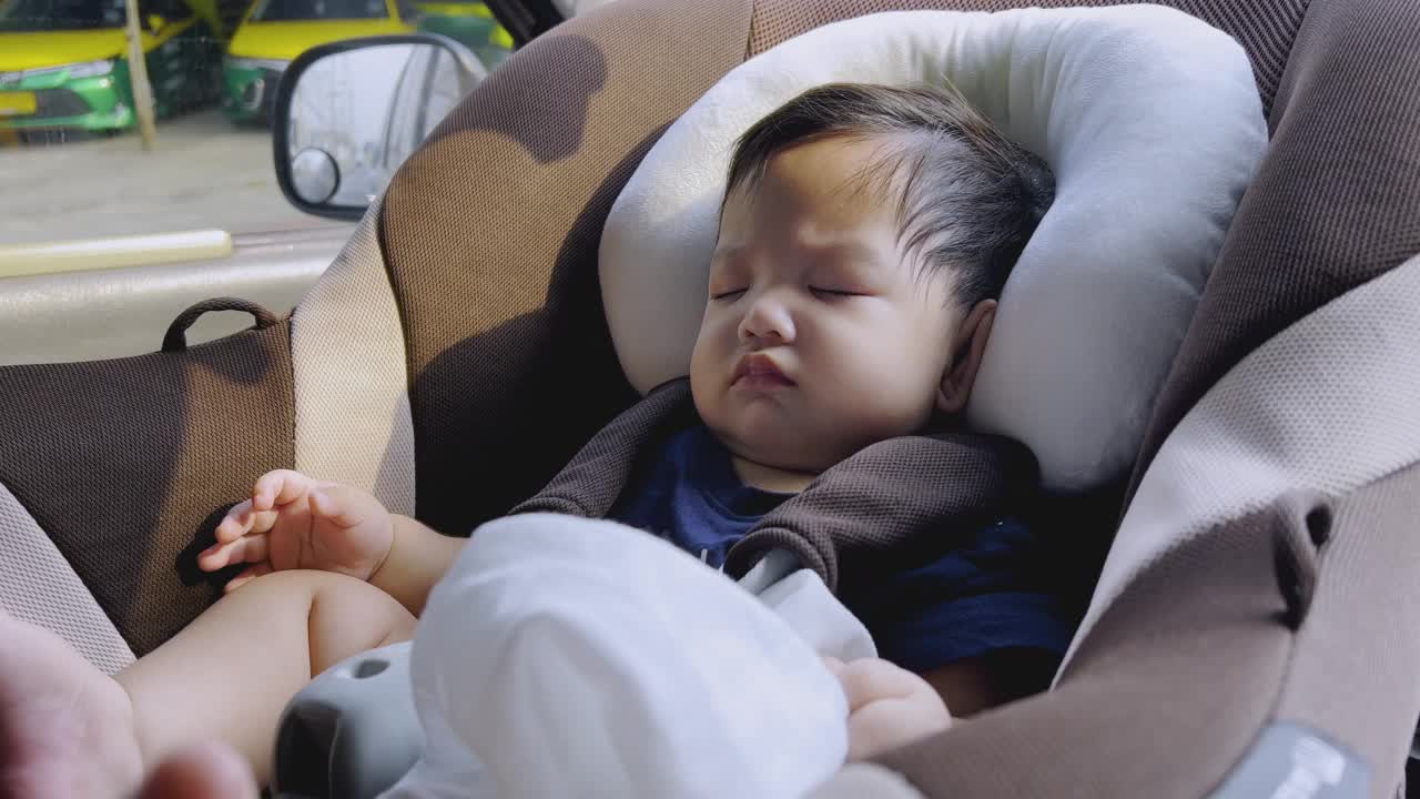 亚洲小男孩睡在汽车座椅上，曼谷的城市生活。视频素材