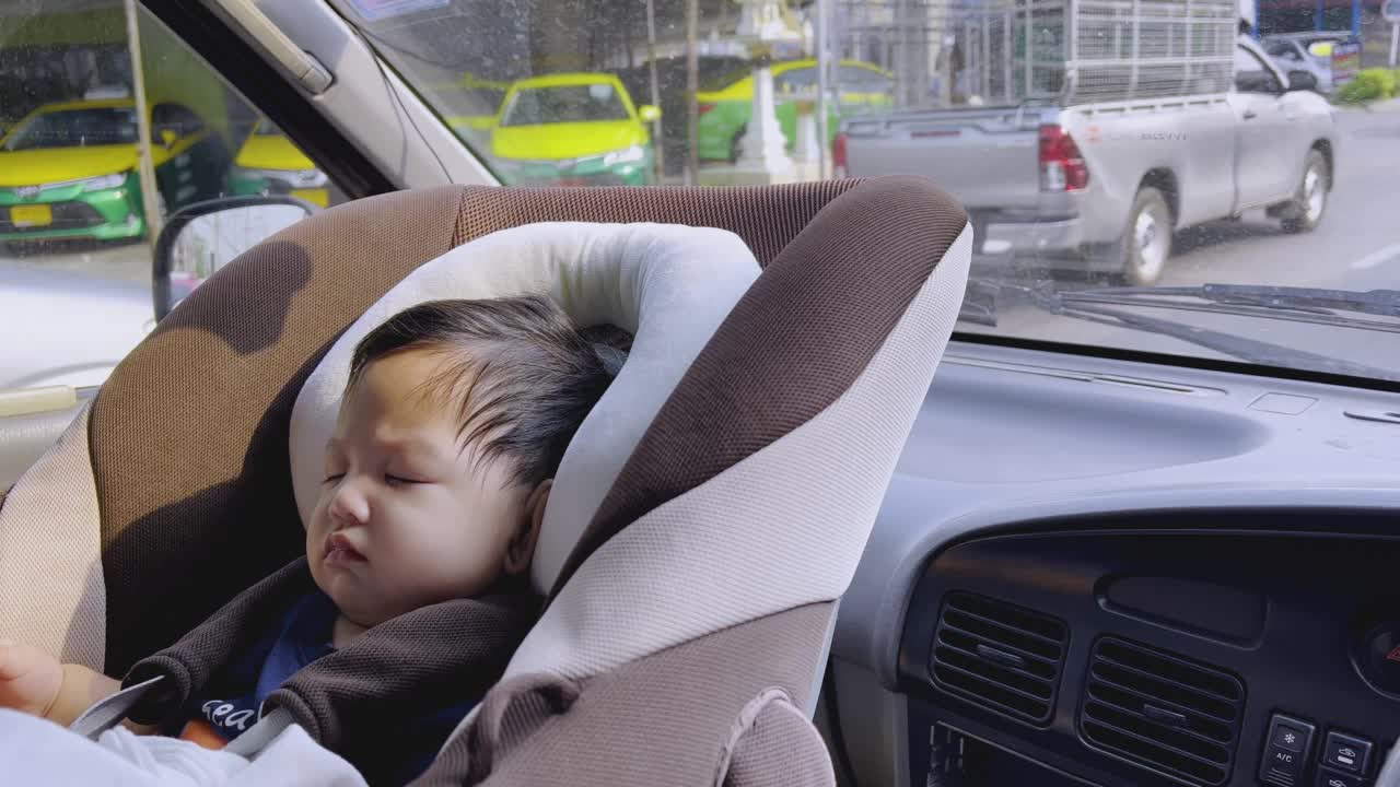 亚洲小男孩睡在汽车座椅上，曼谷的城市生活。视频素材