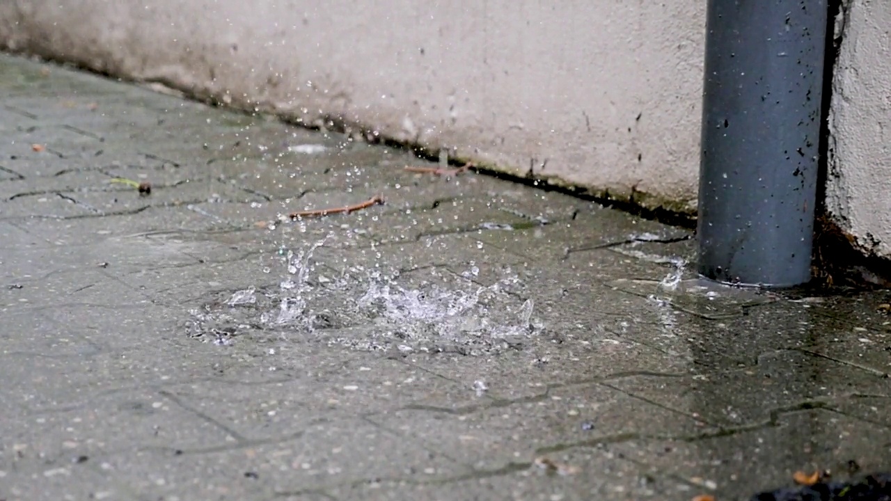 人行道水坑上的雨滴视频素材