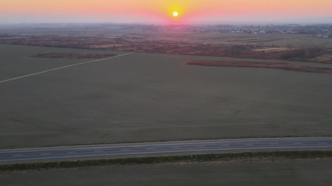 城际公路的鸟瞰图与快速驾驶的汽车在日落。夜间公路交通的无人机俯视图视频素材