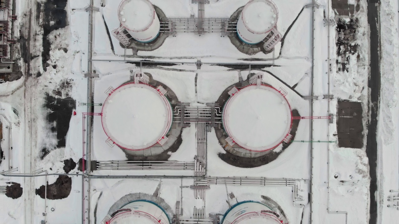 冬季油气储备。冬季油罐俯视图。一架无人机飞过一座炼油厂。世界燃料危机，石油和天然气价格上涨的世界经济由于制裁。视频素材