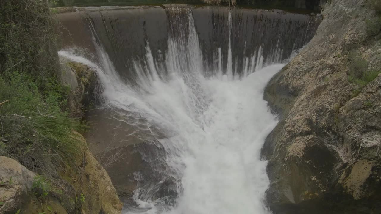 河水从水坝上方流出。视频素材