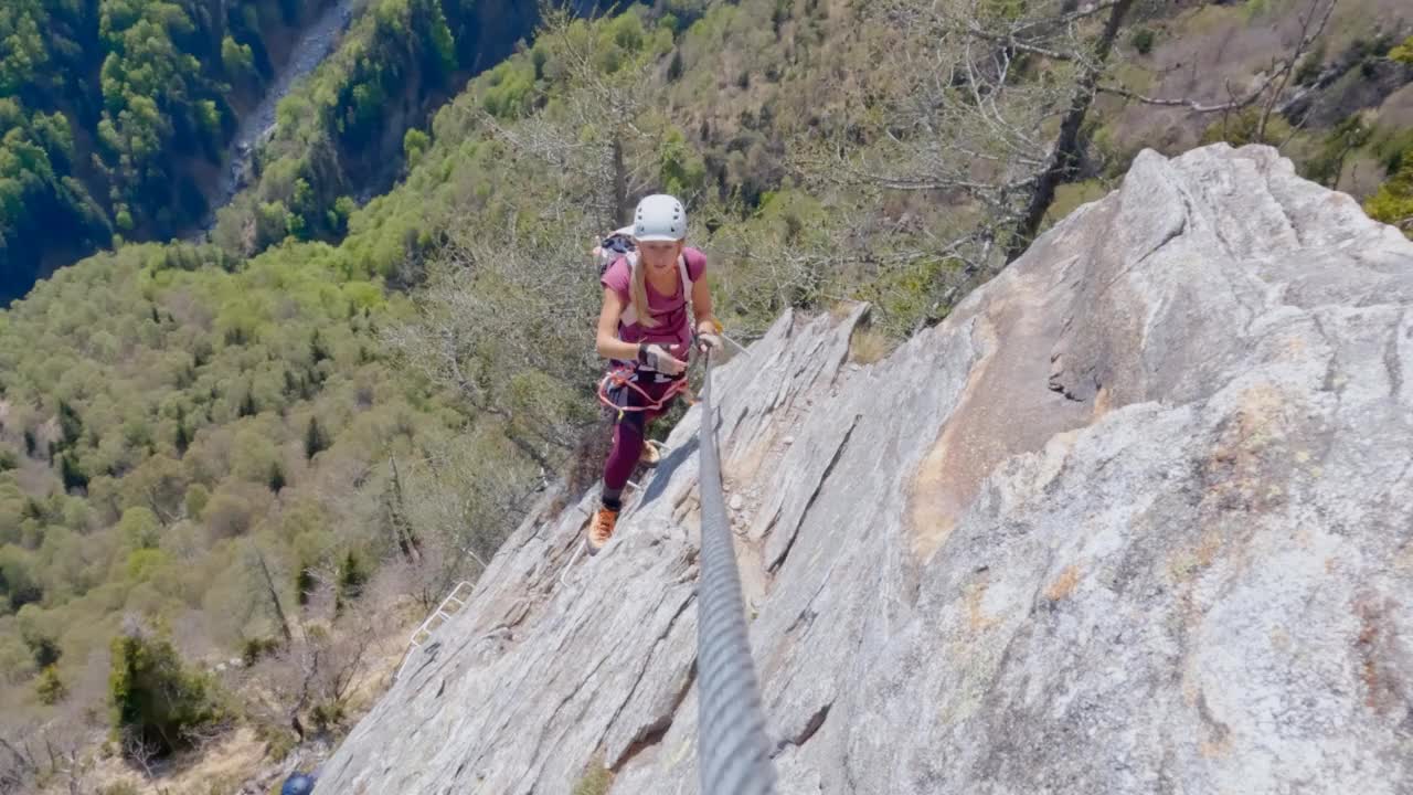 年轻女子沿着费拉塔路线攀登岩石山脊视频素材