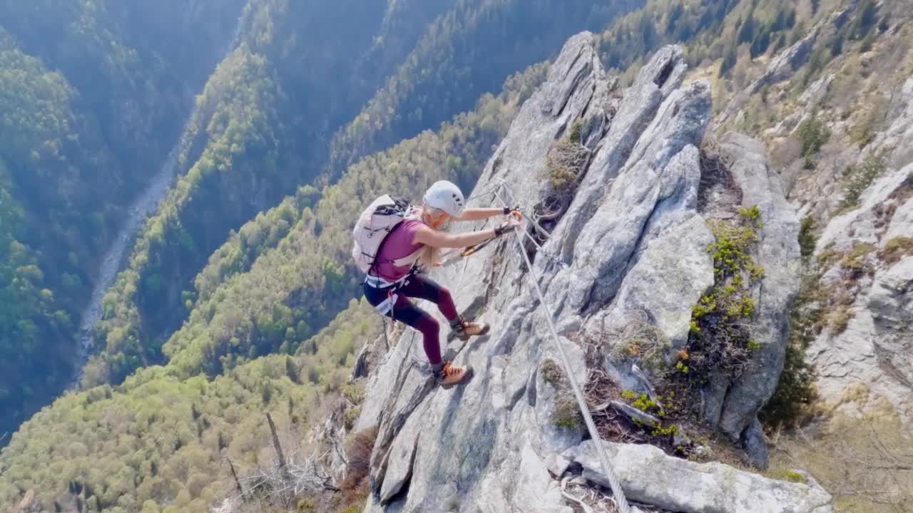 年轻女子沿着费拉塔路线攀登岩石山脊视频素材