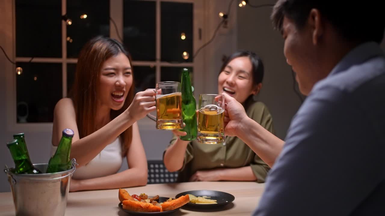 亚洲朋友在庆祝节日，他们碰杯啤酒视频素材