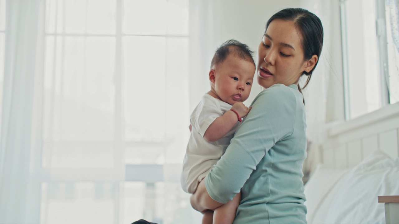 年轻的亚洲母亲和婴儿在客厅视频素材