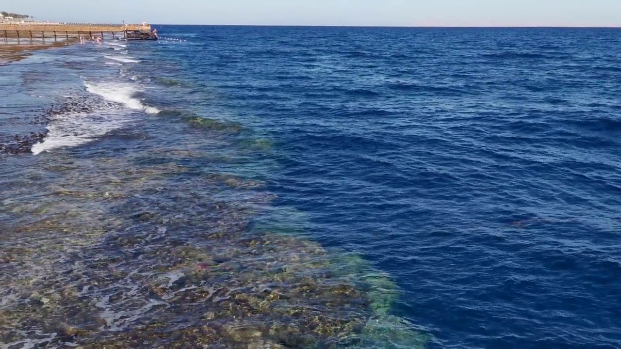 海浪、岩石和沙子的景色。海岸水背景视频素材