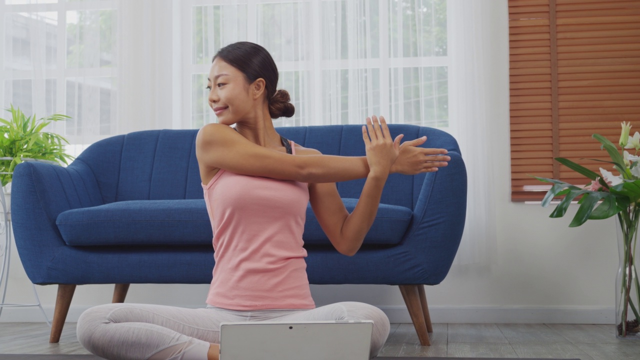 居家女性用数字平板在线学习瑜伽。牛脸姿势，鹰臂姿势的Gomukasana, Dolly滑球射击视频素材