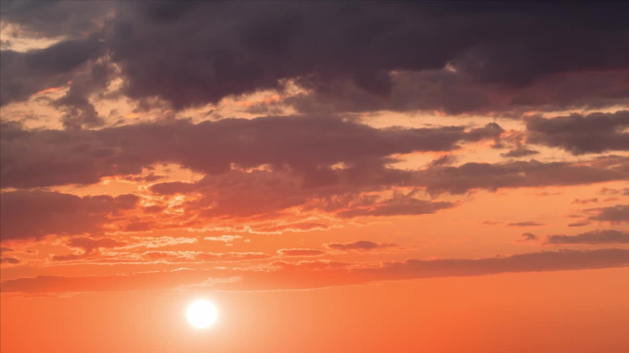 时间流逝。巨大的太阳移动在日落的天空与下雨的乌云粉红色和橙色柔和的颜色视频素材