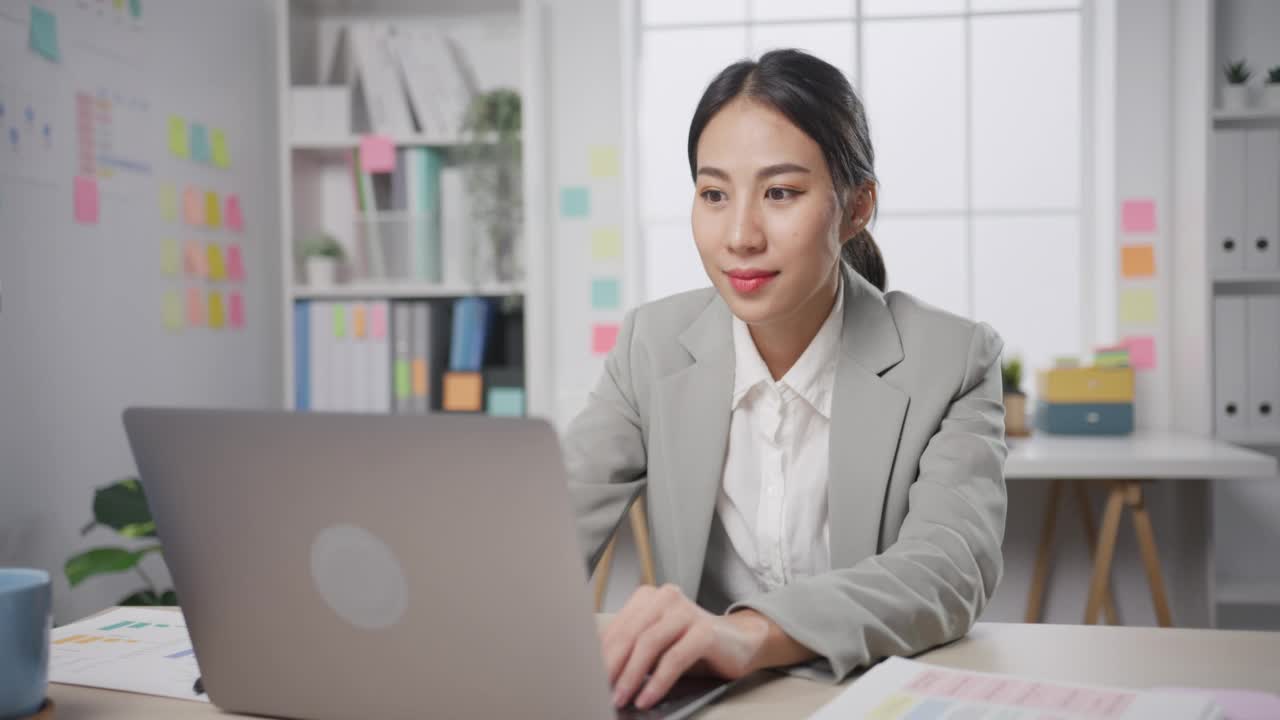 年轻的亚洲女商人坐在桌子上，因过度工作压力而疯狂，愤怒的大量工作在办公室尖叫。视频素材