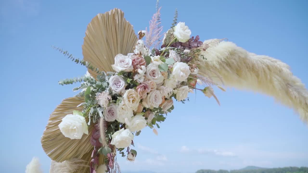 令人惊叹的美丽的婚礼海滩装饰彩色的花朵和蓝天的背景。视频素材