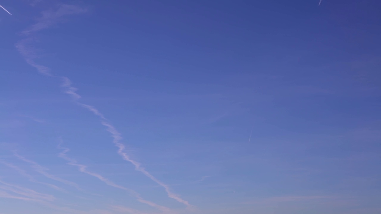 蓝天白云映衬着飞机的轨迹。喷气式飞机凝结轨迹视频素材