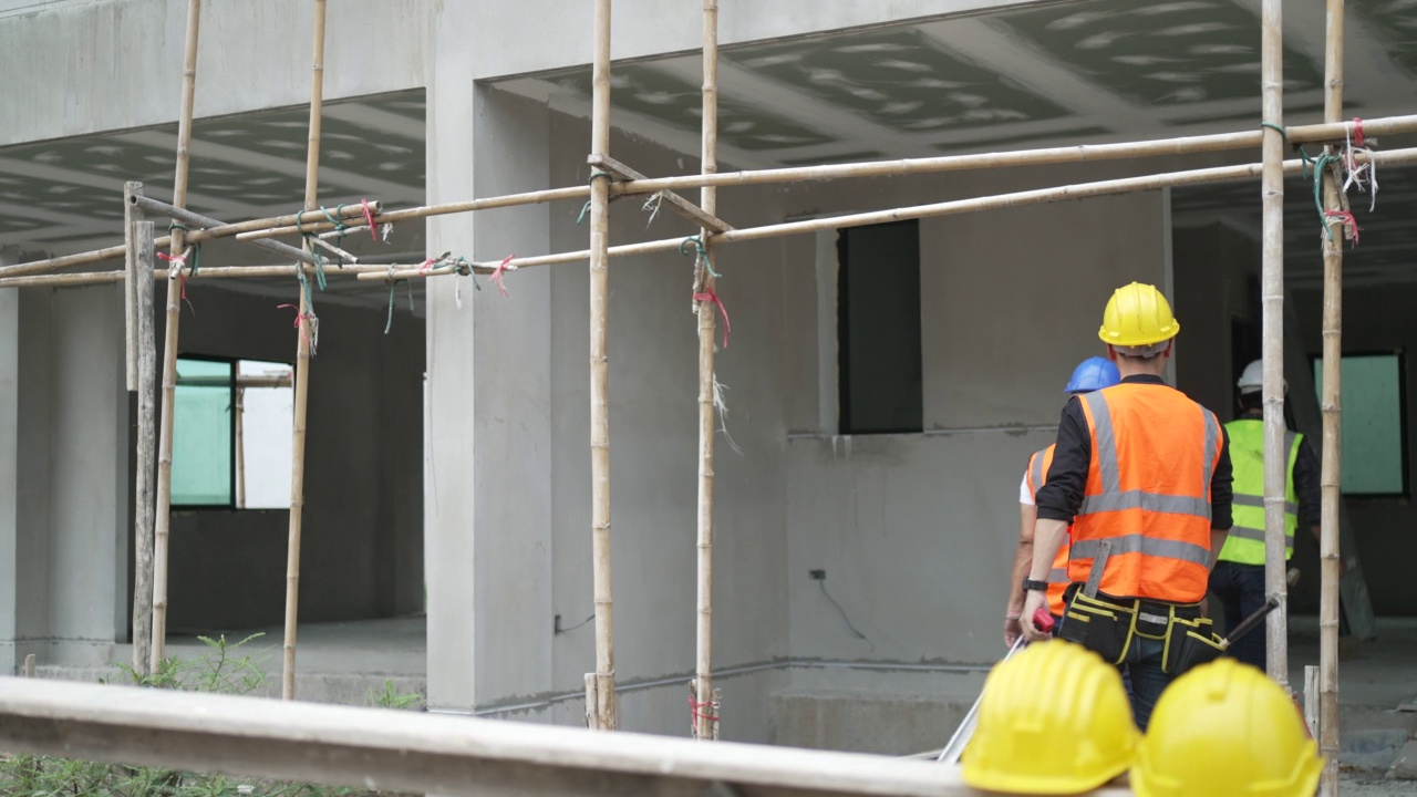 蓝领工人在建筑工地与同事一起工作。视频素材