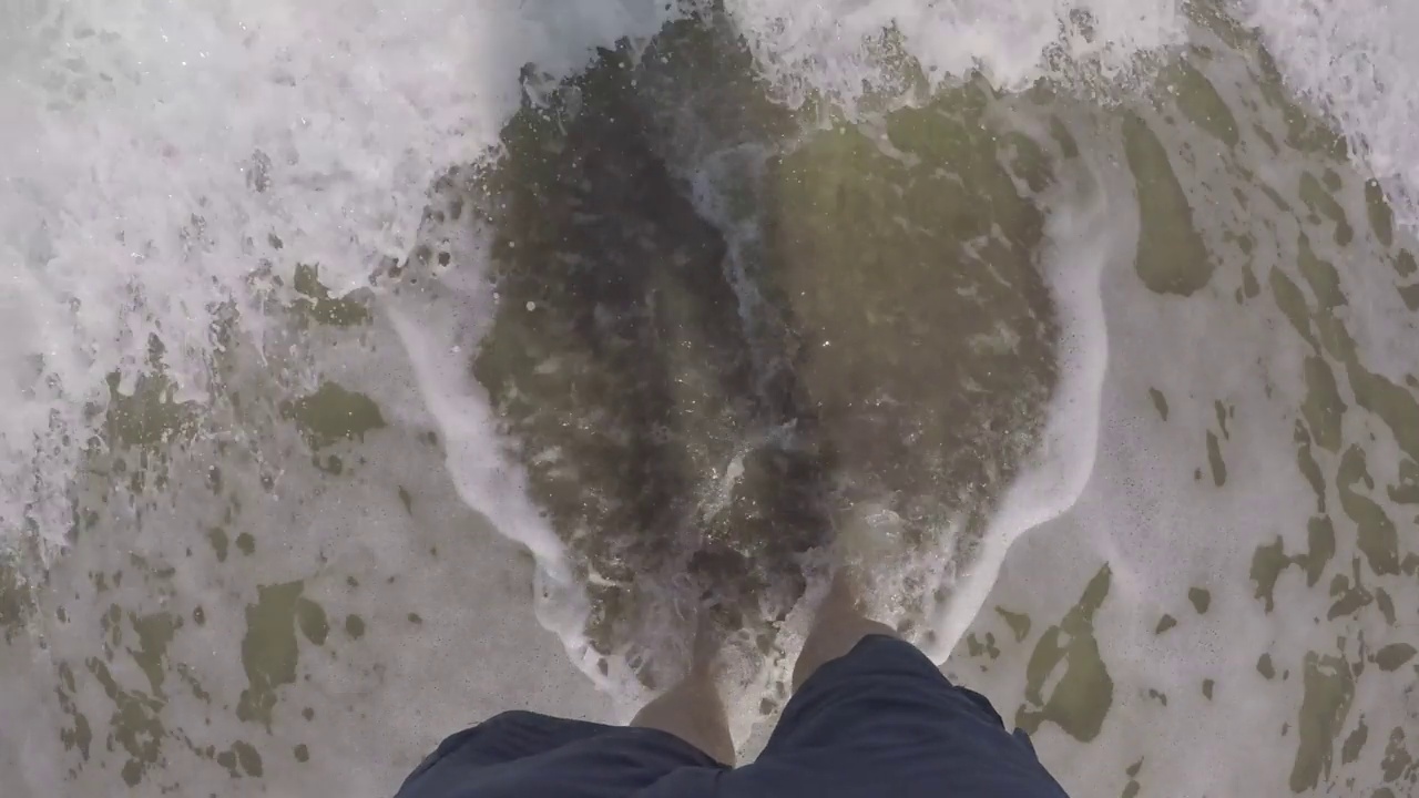 脚上的海滩景色。海水浸湿了沙滩上的双脚。巴西海滩视频素材