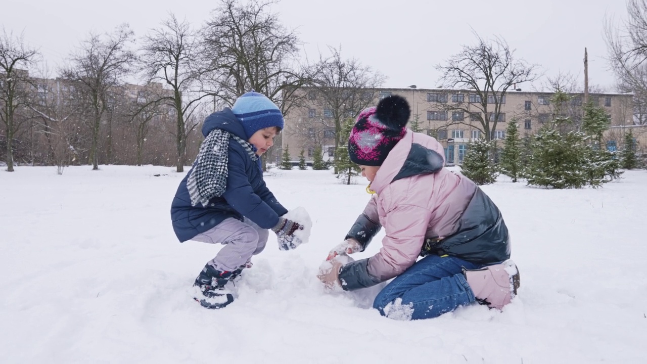 冬天孩子们在公园里堆雪人视频素材