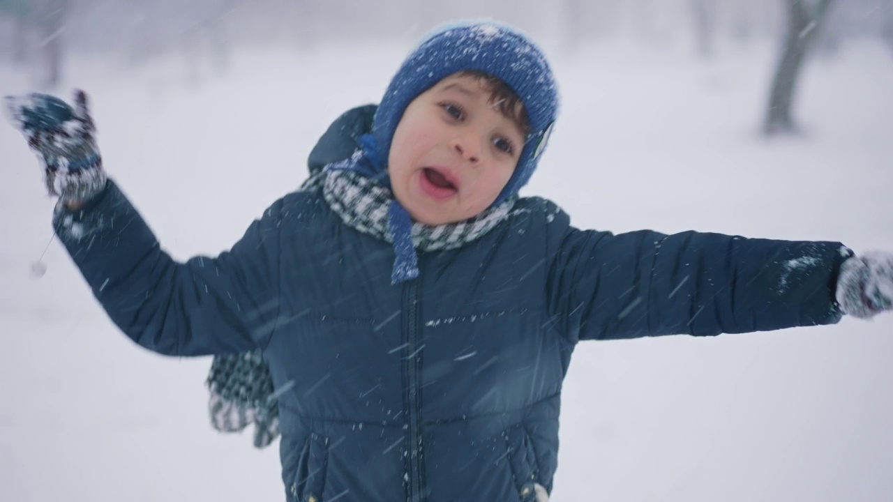 一个男孩在公园的雪地里散步视频素材