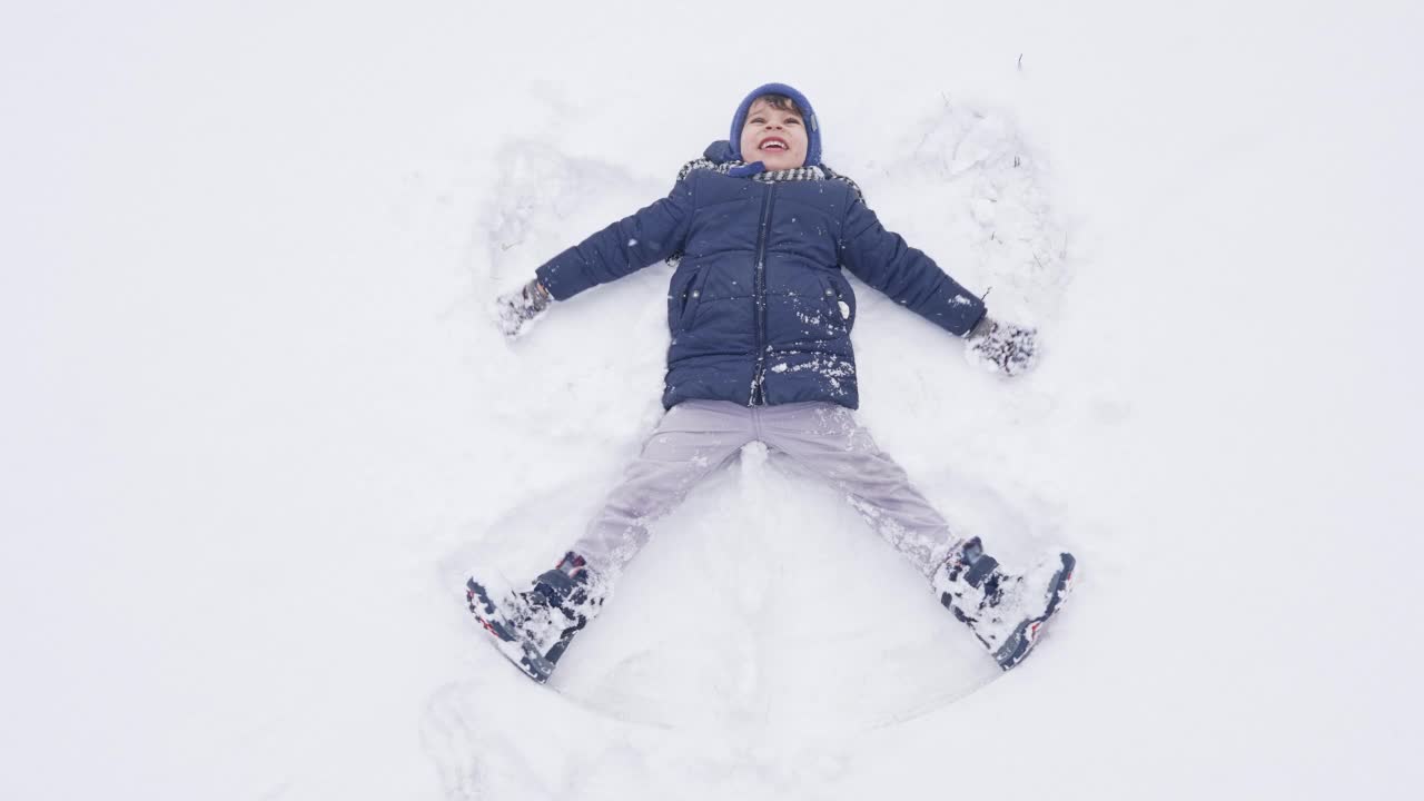 快乐男孩做雪天使视频素材