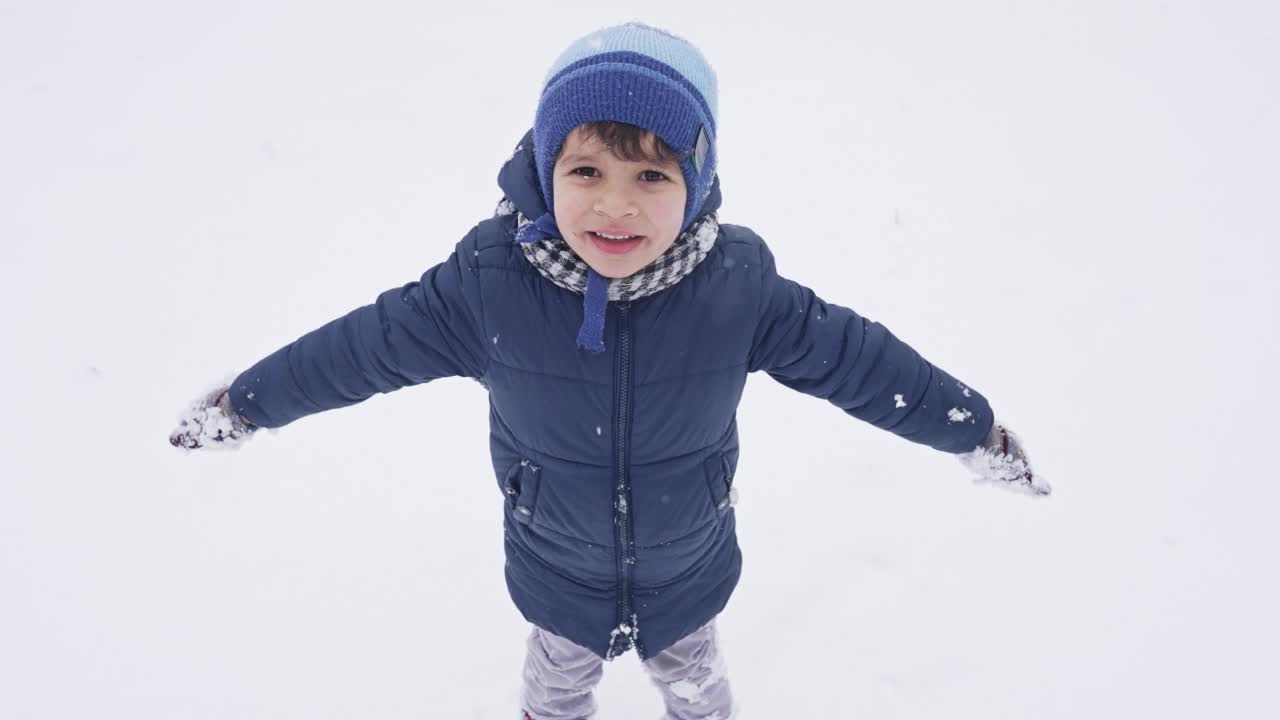 快乐的男孩落在雪地上视频素材