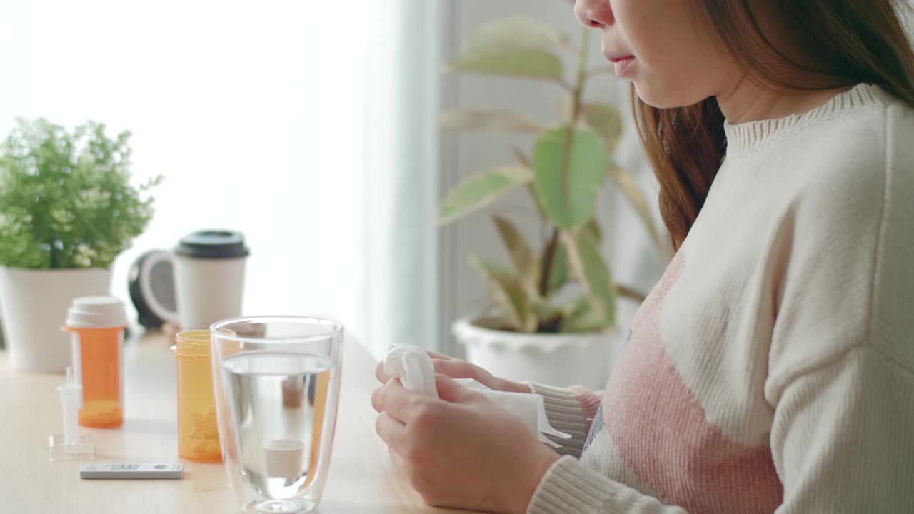 有魅力的女人在家庭房间里吃药喝水视频素材