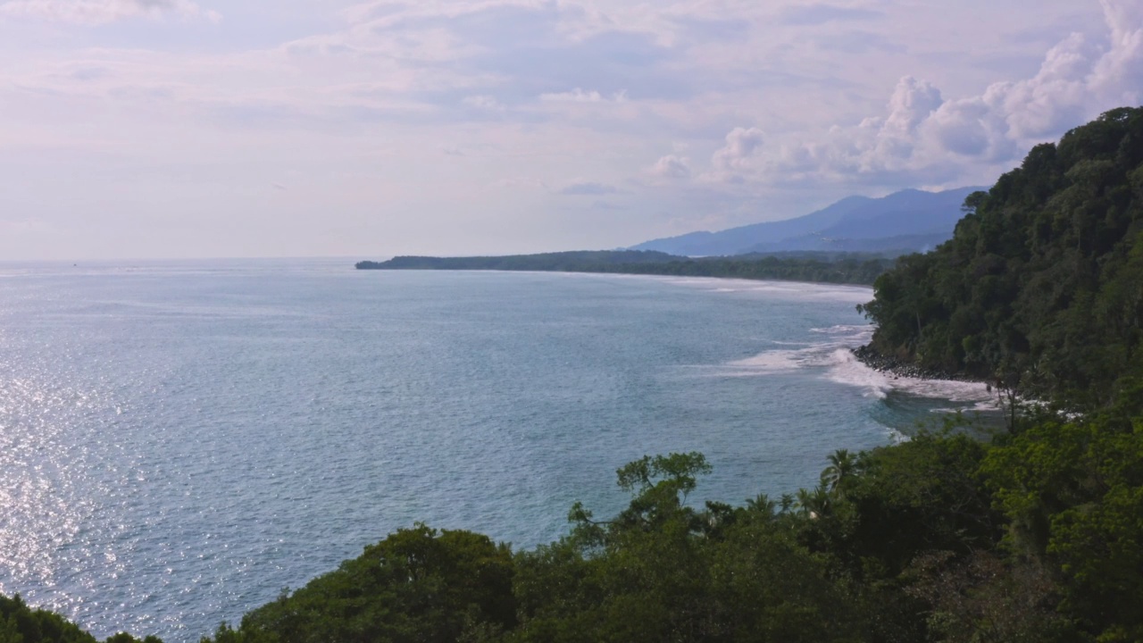 在哥斯达黎加太平洋海岸的热带雨林的无人机视图，沿海热带丛林景观与海洋和美丽的海岸线，中美洲的一个戏剧性的海景视频素材