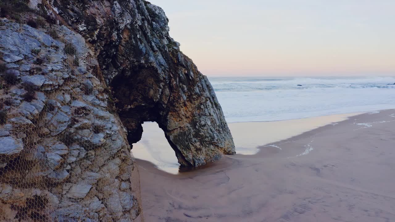 在葡萄牙海岸，Sintra在Praia da Adraga，一个大西洋上的美丽沙滩上，用无人机拍摄的拱形岩石形成的里斯本海滩视频素材