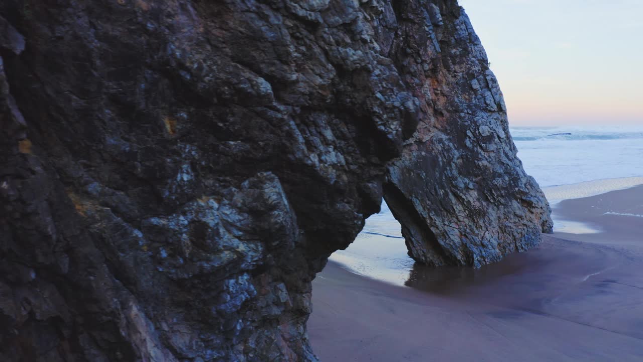 在葡萄牙海岸，Sintra在Praia da Adraga，一个大西洋上的美丽沙滩上，用无人机拍摄的拱形岩石形成的里斯本海滩视频素材