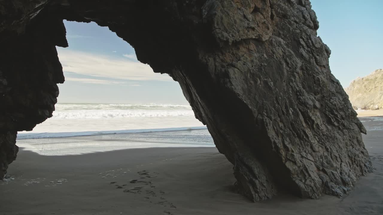 里斯本海滩和戏剧性的葡萄牙海岸，拱形岩石形成，美丽的海岸风景和风景在普拉亚达阿德拉加，辛特拉，葡萄牙，欧洲，大西洋视频素材