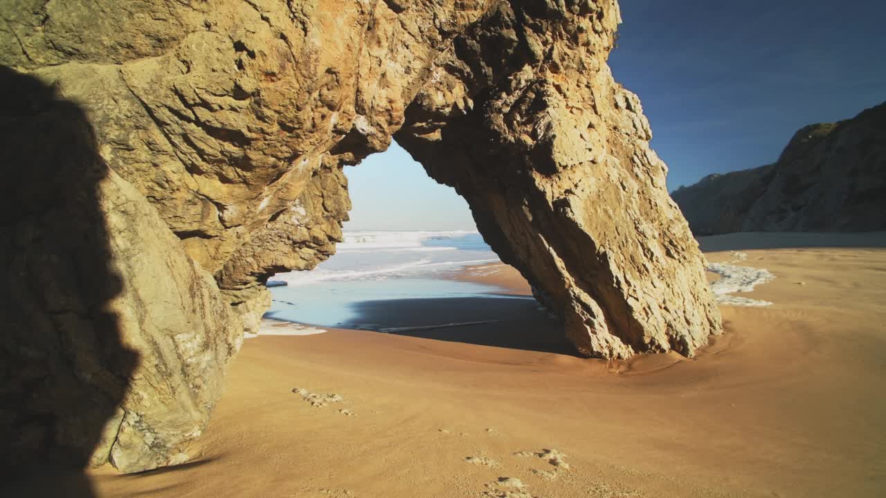 里斯本海滩和戏剧性的葡萄牙海岸，拱形岩石形成，美丽的海岸风景和风景在普拉亚达阿德拉加，辛特拉，葡萄牙，欧洲，大西洋视频素材