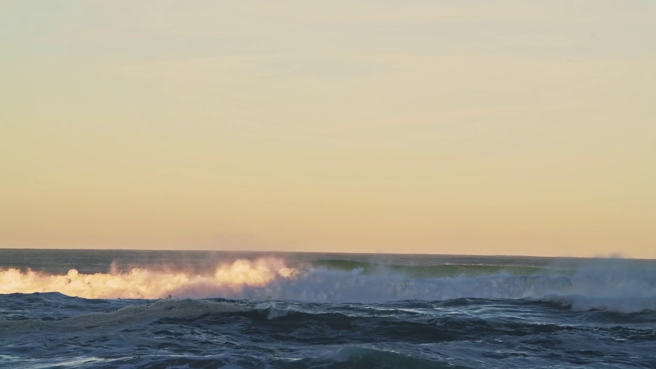 海浪打破的背景在戏剧性的橙色夕阳光，海崩溃从低角度与复制空间地平线视频素材