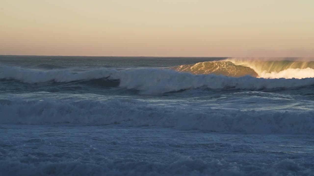 海浪打破的背景在戏剧性的橙色夕阳光，海崩溃从低角度与复制空间地平线视频素材