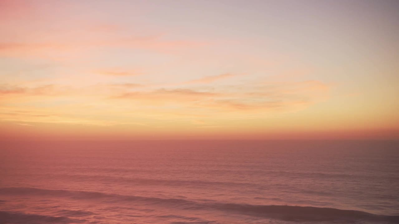 戏剧性的日落云在地平线和波浪打破在海洋的背景与复制空间，从无人机视角的橙色海景海岸场景视频素材