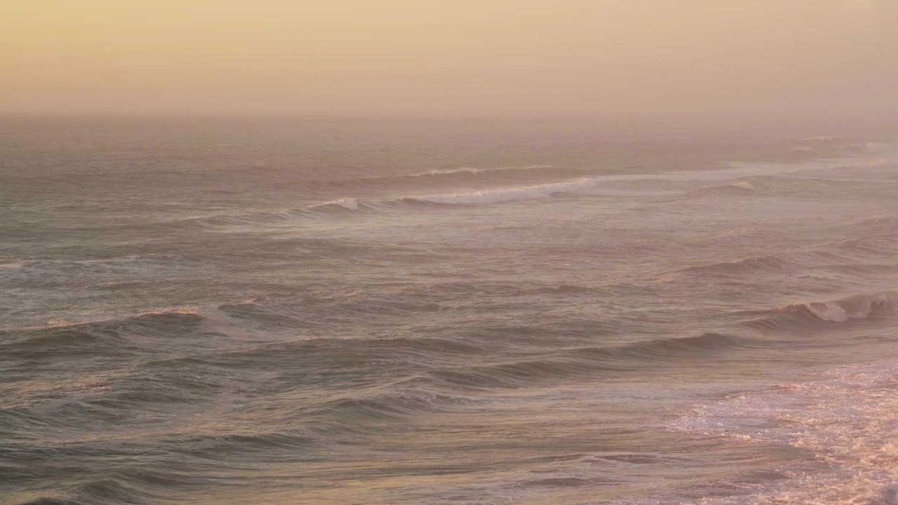 可持续可再生能源水电，大海海浪冲击和打破大海的海景，橙色日落背景与复制空间视频素材