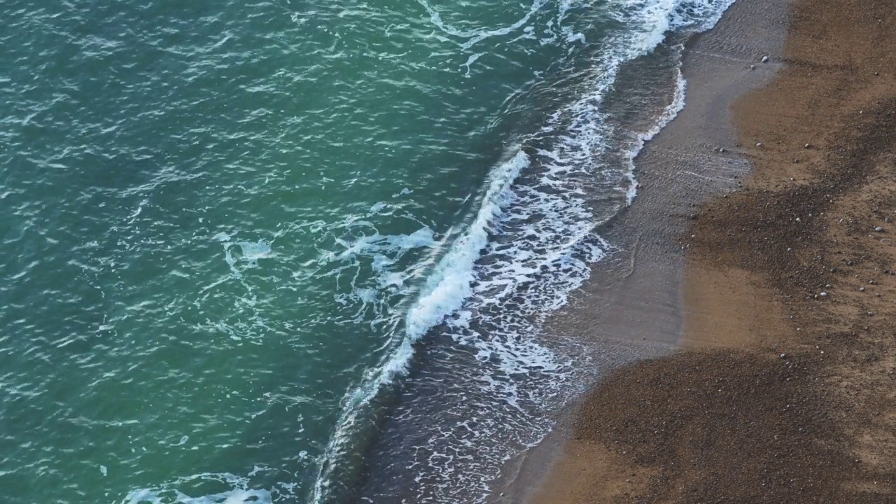 可持续可再生水力发电的无人机与海浪在海岸的沙滩上破碎，复制空间的背景视频素材