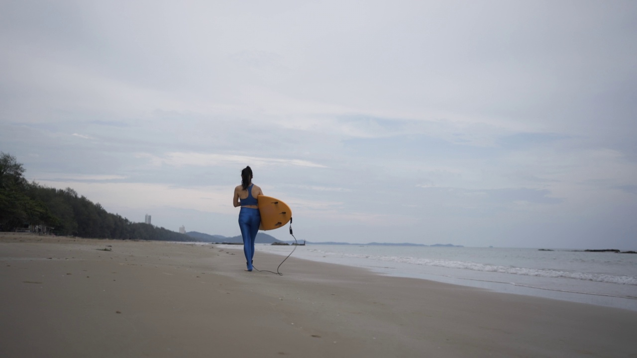 亚洲女子冲浪享受夏天冲浪板在海滩上，泰国。视频素材