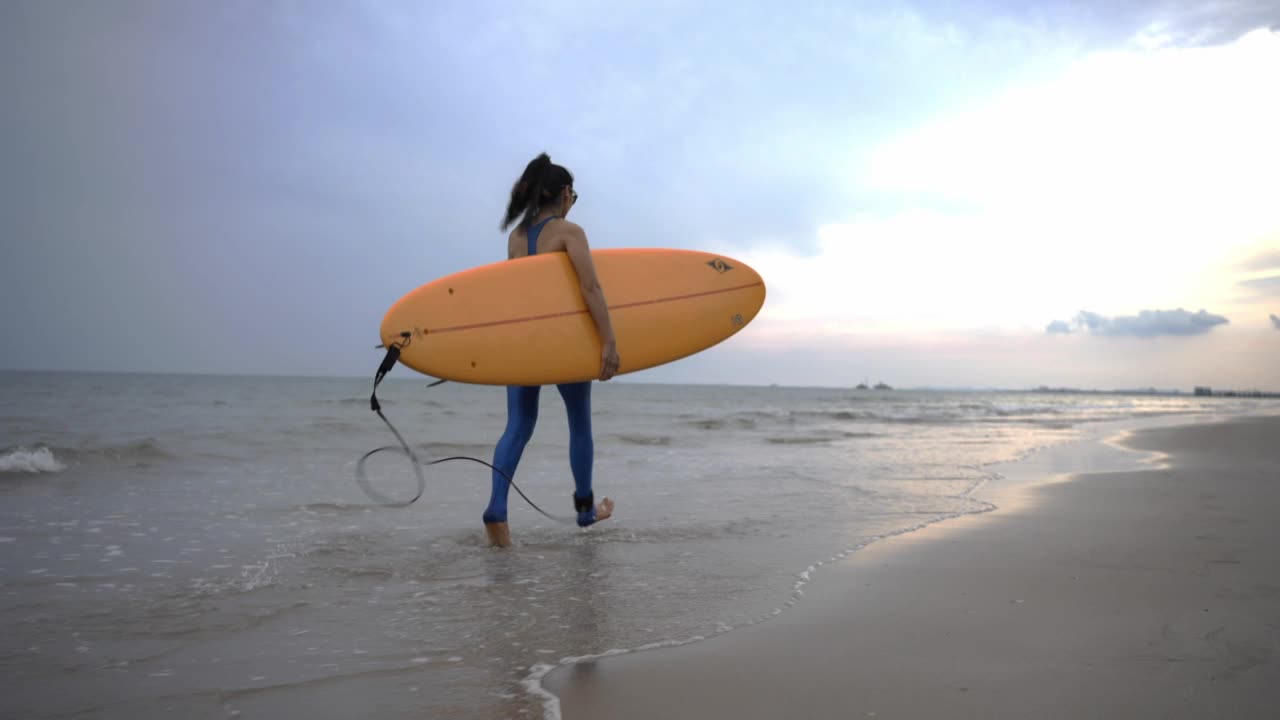 亚洲女子冲浪享受夏天冲浪板在海滩上，泰国。视频素材