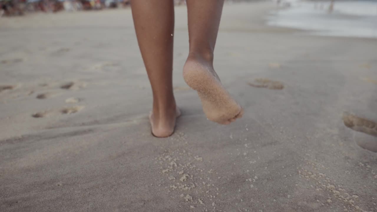 沙滩上的女人腿。女孩走在海边的沙滩上。海滩旅行。暑假的概念。视频素材