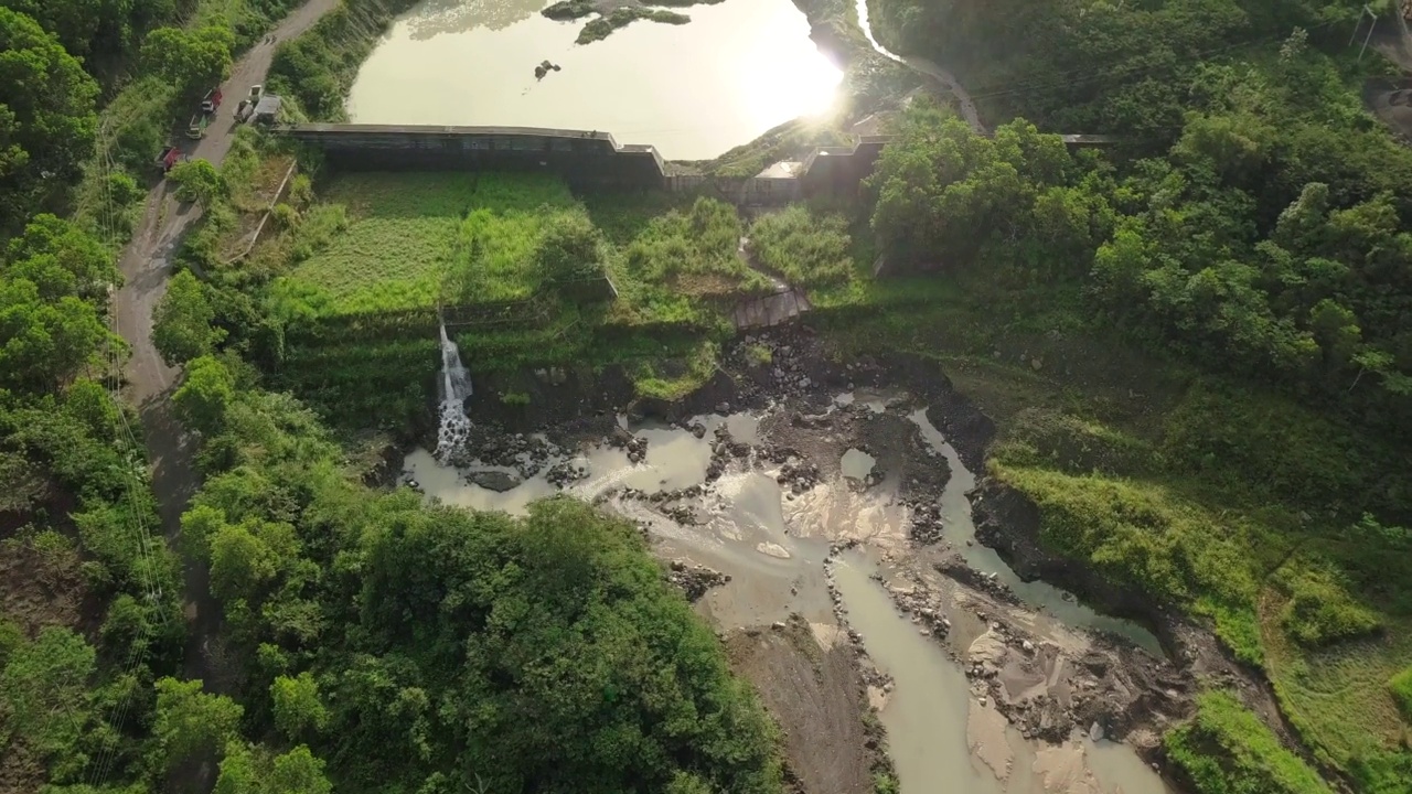 湖水因采矿活动而呈现绿色，周围环绕着茂密的森林视频素材