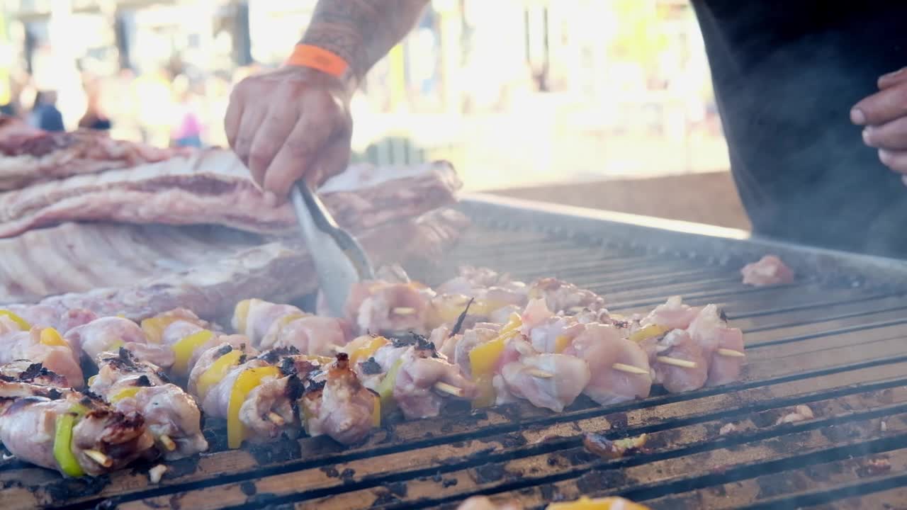 烤鸡肉和黄椒串在烤架上烤熟，准备烧烤街头小吃视频素材