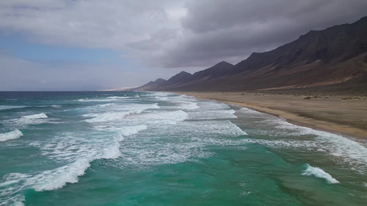 低空飞行的海浪飞溅到沙漠沙滩Playa de Cofete，詹迪亚半岛富埃特文图拉，加那利群岛，西班牙视频素材