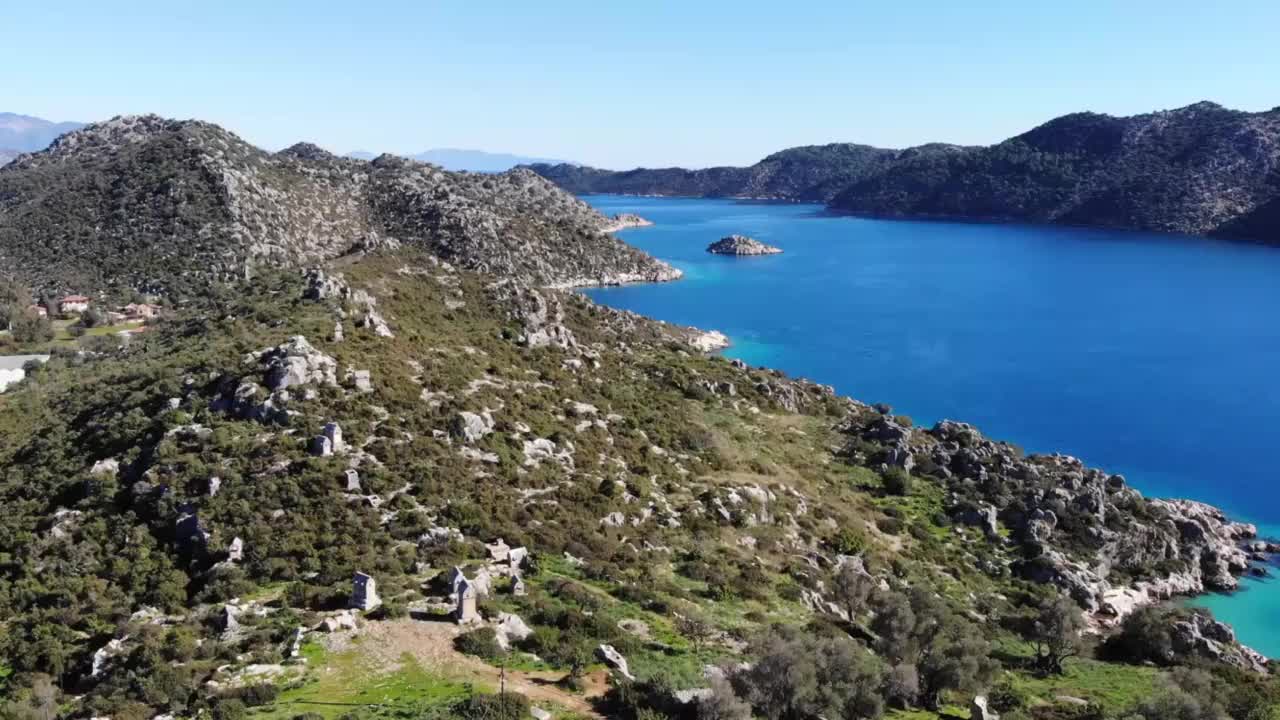 阳光明媚的日子鸟瞰有海通道的山景视频素材