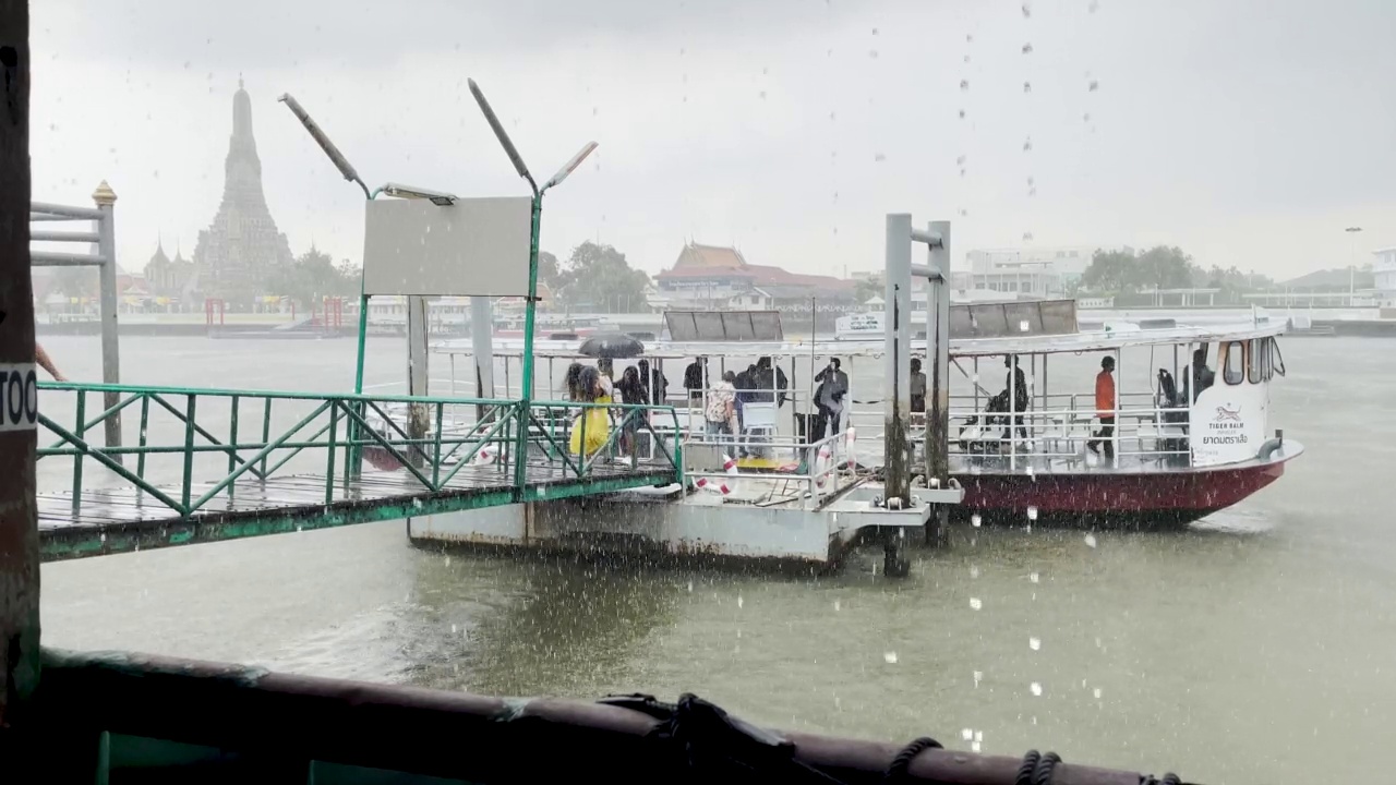 闪电风暴袭击曼谷，带来强风和暴雨，导致洪水泛滥。乘客在曼谷湄南河渡船码头被困在恶劣的条件下，阿伦在背景中。雾多雾雷暴闪电极端天气条件视频素材