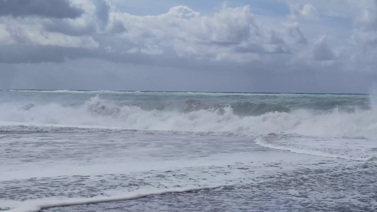 沙滩上美丽的海浪。美丽的晴天海浪穿越海滩沙滩。海景资料片。蓝色的水面波浪表面，美丽的背景与复制空间。视频素材