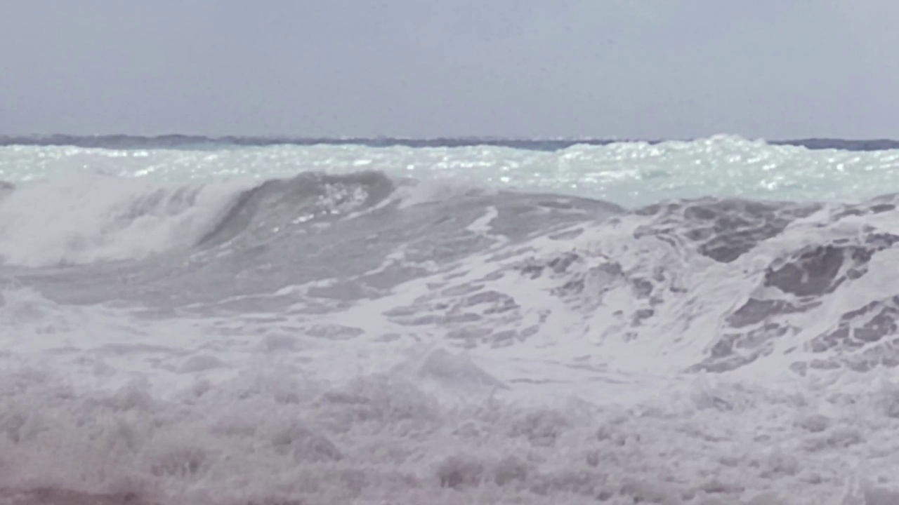 海浪拍打岩石的慢动作。江水和海水的波浪在涨潮和退潮时相遇。第勒尼安海漩涡，卡拉布里亚，意大利。视频素材