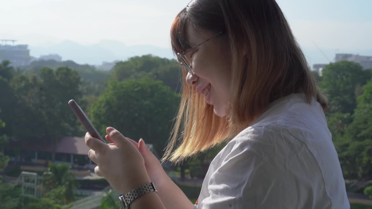 年轻女性在户外使用智能手机视频素材