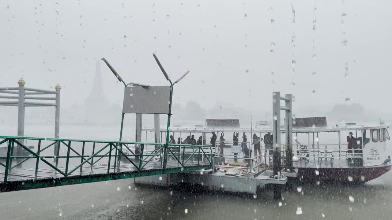 闪电风暴袭击曼谷，带来强风和暴雨，导致洪水泛滥。乘客在曼谷湄南河渡船码头被困在恶劣的条件下，阿伦在背景中。雾多雾雷暴闪电极端天气条件视频素材