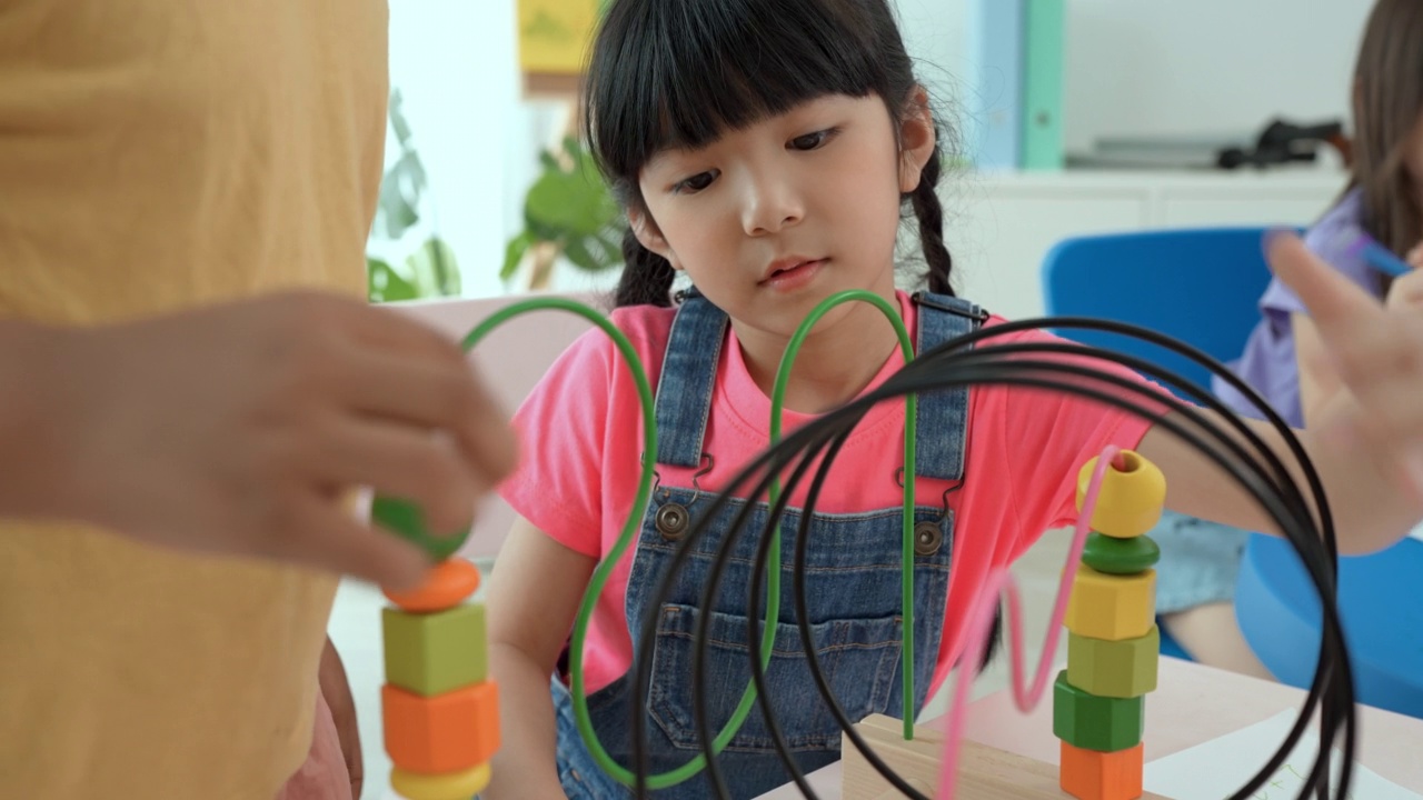 快乐的两个孩子在玩拼图。学前班和幼儿园儿童的益智玩具。第一次到学校接受教育和在幼儿园玩耍，童年教育理念。视频素材