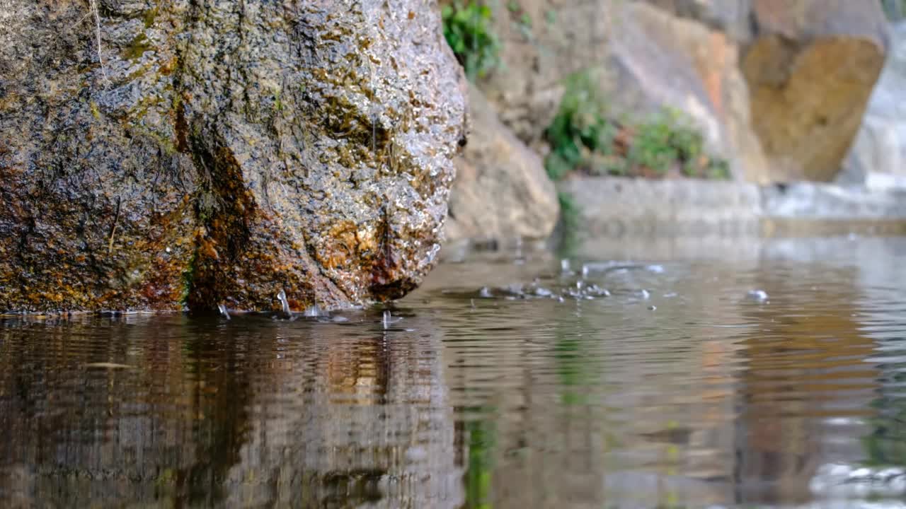 泉水倾泻而下，滴落在青苔上。视频素材