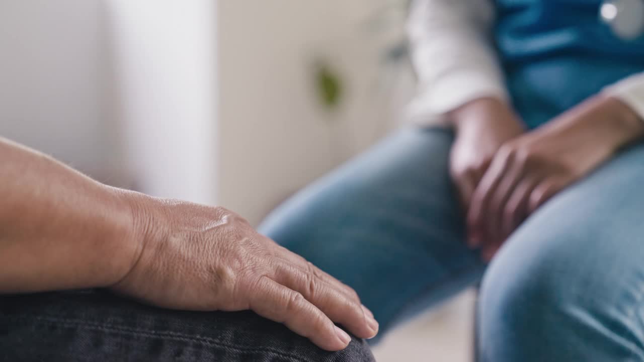 女医生或护士握着老年男性病人的手，特写视频素材