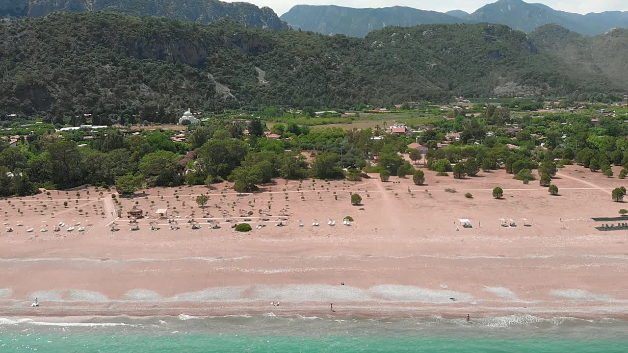 宽阔的沙滩映衬着山峰。美丽的地中海海岸线，清澈宁静的海水表面在阳光明媚的夏天。热带岛屿，碧蓝的海水和山脉视频素材